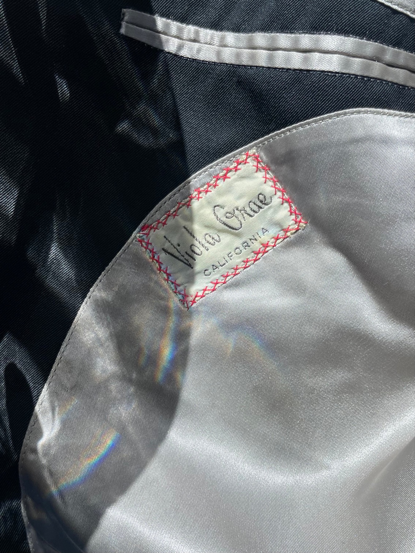 Seller-presented close view of the Viola Grae / California label inside the black embroidered jacket.