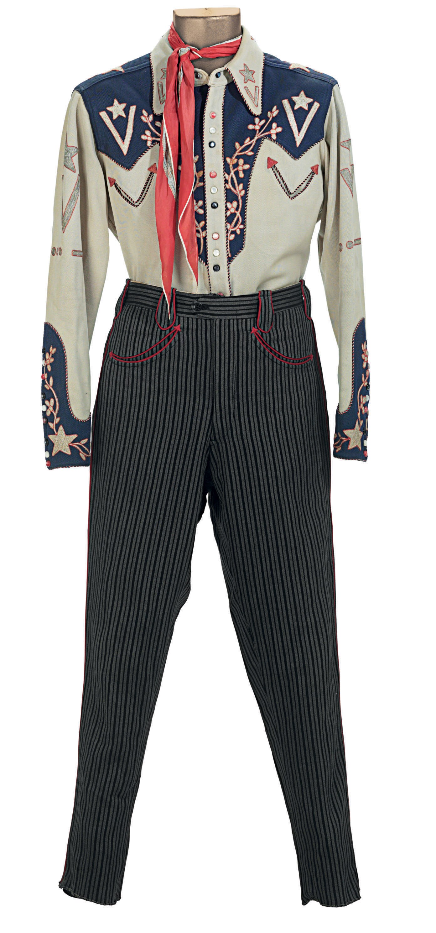 Christie’s 2010 lot-126 photograph of an auction-presented blue-yoked, embroidered Rodeo Ben ensemble with striped trousers and scarf.