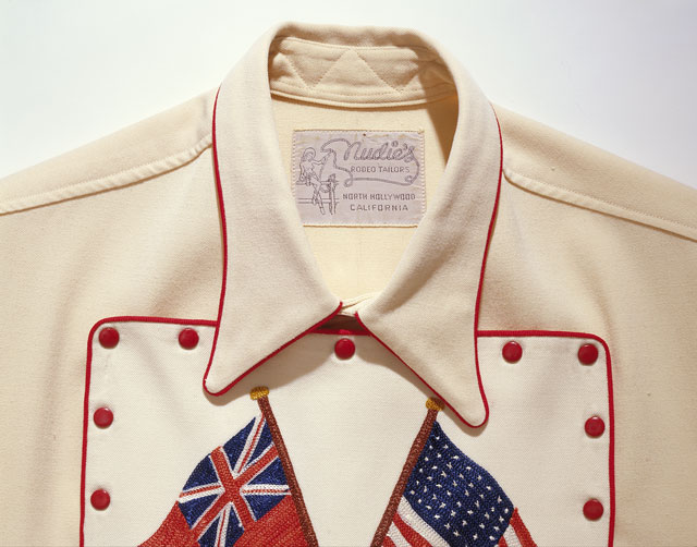 Close view of the Nudie’s Rodeo Tailors label and red-piped bib on the Gene Autry shirt, Autry object 91.221.505.